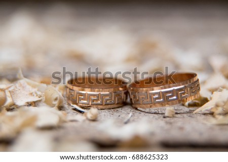 Golden wedding rings with wood chip flakes focus selected