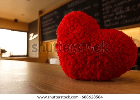 Red heart on table in coffee shop