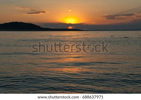 Beautiful attractive colorful sunset on orange cloudy sky over calm quiet sea water. Seascape at twilight. Summer relax and romantic concept.  