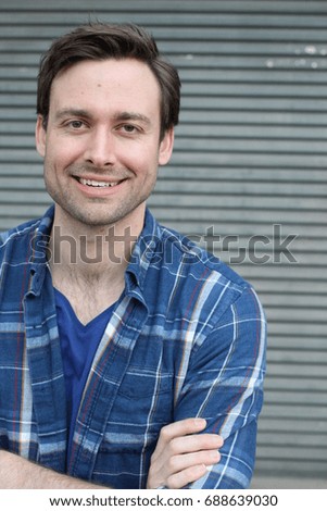 Natural good looking young man smiling with arms crossed