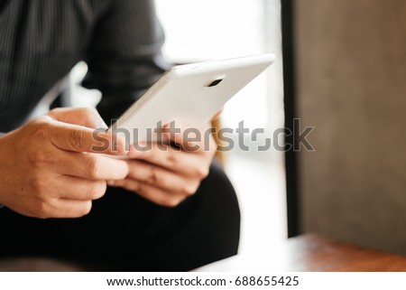 front view. business man holding tablet touch on black screen. sitting at coffee cafe in morning time. image for business,education,mobile,technology,workplace,people concept