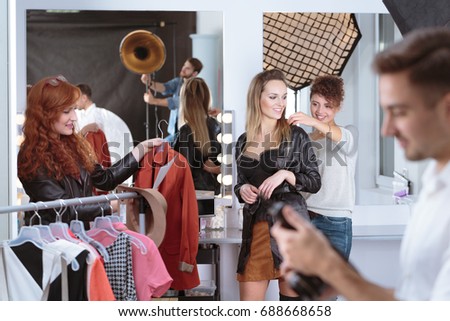 Young dresser preparing clothes for young pretty model