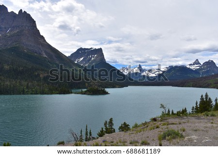 Picture of Beautiful Lake Sherburne with the snow capped mountains that surround Many Glacier in the background.  Picture taken from a hiking trail inside Glacier National Park.  