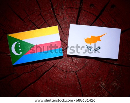 Comoros flag with Cypriot flag on a tree stump isolated