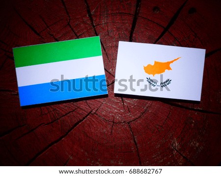 Sierra Leone flag with Cypriot flag on a tree stump isolated