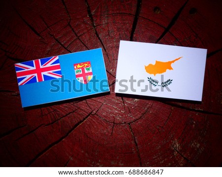 Fijian flag with Cypriot flag on a tree stump isolated