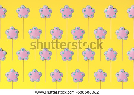 Topper. Pattern of homemade gingerbreads in the form of pink flowers on the yellow background. Picture for a menu or a confectionery catalog. Invitation or greeting card.