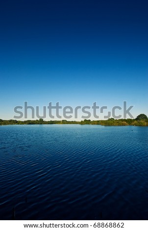 The picture shows a lake and a blue sky.