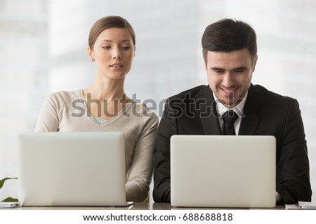 Interested curious corporate spy looking at colleagues laptop, spying on rival, cheating on examination, stealing idea, sneaking peek, taking inquisitive glance at computer screen of unaware coworker Royalty-Free Stock Photo #688688818