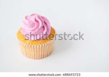 Cupcake with pink whipped cream on white background. The image with copy space. Background for the confectionery menu, cards, greetings, birthday invitations.