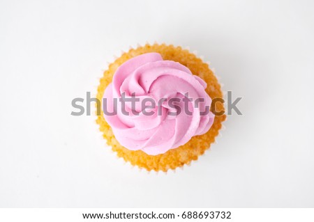 Cupcake with pink whipped cream on white background. The image with copy space. Background for the confectionery menu, cards, greetings, birthday invitations. Top view