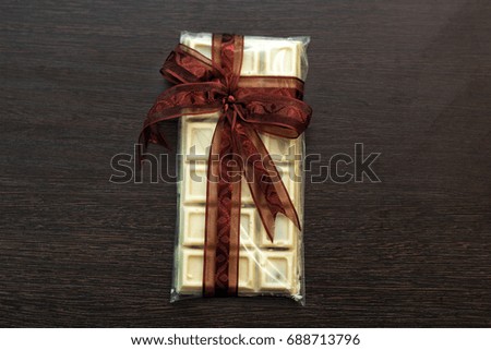 tile of white chocolate in packaging with brown bow.
