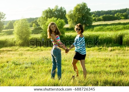 Mother and daughter holding hands. Photo on nature in a sunny summer day