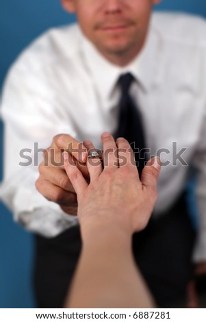 A man proposing and putting a ring on a woman's finger