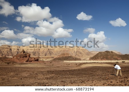 Man is taking picture of desert and rocks in Timna national park in Israel