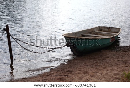 Fishing boat bound to shore. Boat on a Lake Coast.