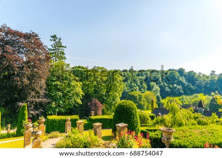 Beautiful park in antique style, stone decorations on pedestals, beautiful plants, resting place