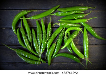 Green chilies on woven edge plate made of wood