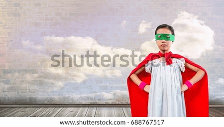 Digital composite of Superhero girl with sky clouds wall