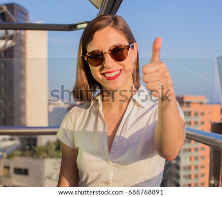 young woman in a rooftop okay sign