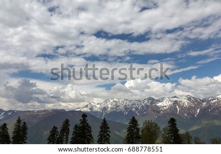 Spring in the mountains of Sochi, Krasnaya Polyana, landscape view with trees in front and clouds above
