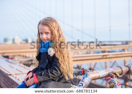 Adorable little girl sitting at Brooklyn Bridge