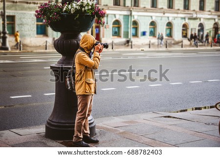 Photographer taking a shot by his camera on street. Travel photography concept, copy space