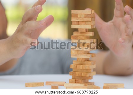 Close up of hand playing with the wooden blocks stack game for meditation practice. Concept of education, risk, development, planning, strategy, and growth.