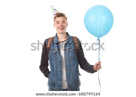 Portrait of handsome college boy in party hat celebrating his birthday