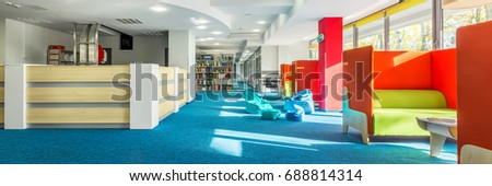 Panoramic view of spacious college library interior with individual study space