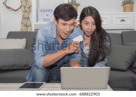 Young man using laptop and woman with happy emotion at living room.