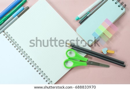 Student and office supplies. Opened notebook and office props on pink background with copy space.