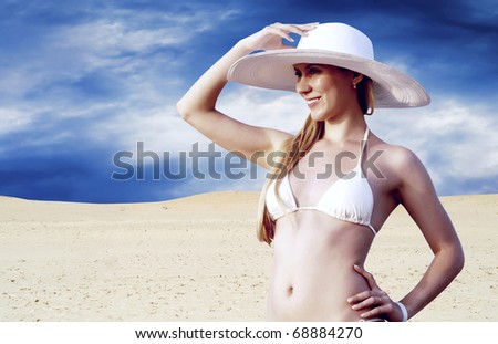 Young beautiful women in whitebikini and hat, relaxation at sunny desert