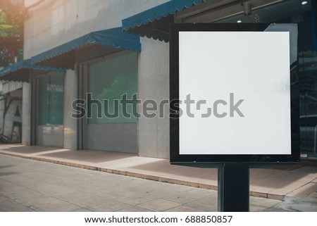 Blank mock up of vertical street poster billboard on city background.