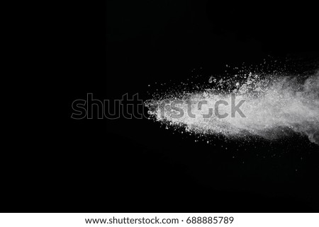 Powder explosion. Closeup of white dust particle explosion isolated on black background
