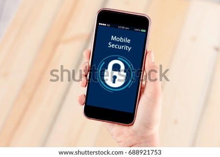 mobile sucrity concept.Hands holding mobile phone on blurred wooden table as background