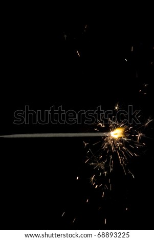 The picture shows a sparkler on black background .