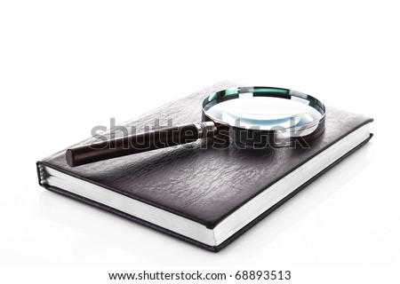 Notebook with a magnifier on it isolated on white