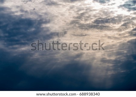 Abstract background, dark and stormy clouds, dramatic sky, with sunlight breaking through clouds, have space for text.