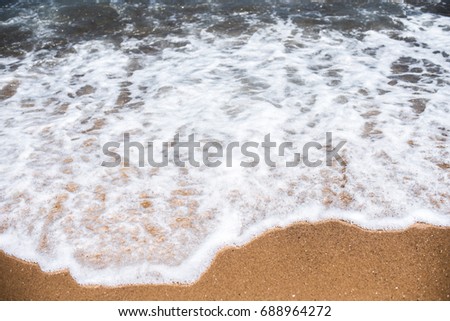 Sand and sea waves on beach at resort, sand texture