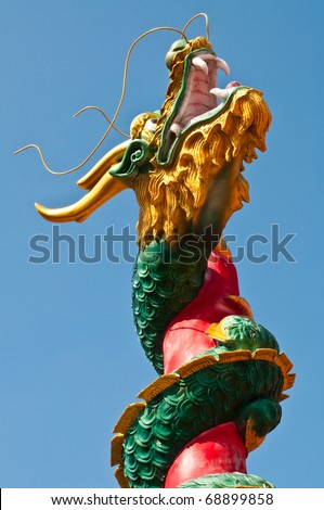 Dragon statue with column on blue screen, Thailand.