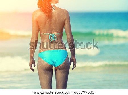 oman smearing mud mask on the body on the beach
