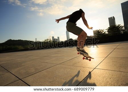 Woman practicing with skateboard at sunrise city