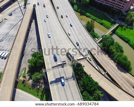 Aerial top view highway I45 (Gulf Freeway), asphalt elevated road and Bayou River in downtown Houston, Texas, US. Passenger cars and trucks are commuting at daytime. Urban transportation publication.
