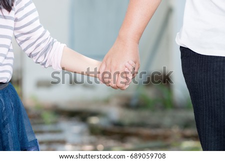 Mother and daughter holding hand in hand, care and love concept