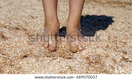 Baby feet standing on the sand close-up