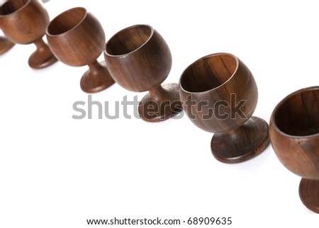 Wooden cups aligned isolated on white background.