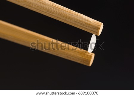 Pick up Rice with chopsticks in black background