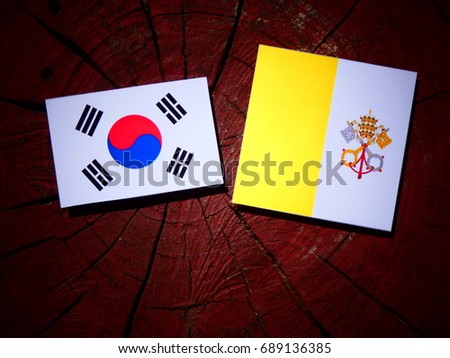 Vatican flag with South Korean flag on a tree stump isolated