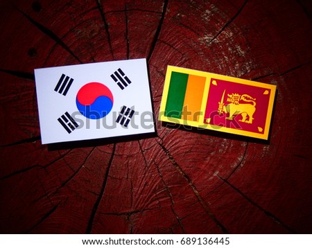 Sri Lankan flag with South Korean flag on a tree stump isolated